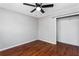 Bedroom with hardwood floors, ceiling fan, and a large closet at 67 Blue Springs Sw Ct, Lilburn, GA 30047