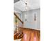 Bright foyer featuring hardwood floors, a modern light fixture, and a classic paneled front door at 67 Blue Springs Sw Ct, Lilburn, GA 30047