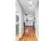 Hallway with hardwood floors leading to the updated kitchen and the bathroom at 67 Blue Springs Sw Ct, Lilburn, GA 30047