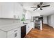 Modern kitchen with white cabinets, quartz counters, stainless steel appliances, and hardwood floors at 67 Blue Springs Sw Ct, Lilburn, GA 30047