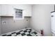 Compact laundry room with checkered floors and cabinets at 67 Blue Springs Sw Ct, Lilburn, GA 30047
