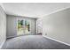 A bright and airy living room featuring neutral paint and plush gray carpeting at 67 Blue Springs Sw Ct, Lilburn, GA 30047