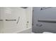 Bathroom featuring accessibility grab bars around a white bathtub and toilet at 1325 Classic Ne Dr, Conyers, GA 30013