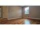 Bedroom features hardwood floors, neutral paint, and a bright window at 1325 Classic Ne Dr, Conyers, GA 30013