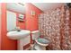 Small, colorful bathroom featuring white fixtures, patterned shower curtain, and orange walls at 760 Josh Ln, Lawrenceville, GA 30045