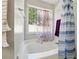 Bright bathroom featuring a white garden tub with a large window letting in natural light at 760 Josh Ln, Lawrenceville, GA 30045