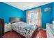 Stylish bedroom with blue walls, hardwood floors, and natural light from a window at 760 Josh Ln, Lawrenceville, GA 30045