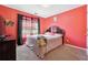 Bedroom features bright orange walls, a window with floral curtains and hardwood floors at 760 Josh Ln, Lawrenceville, GA 30045