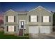 Charming split-level home featuring light-green siding, black shutters, and a convenient two-car garage at dusk at 760 Josh Ln, Lawrenceville, GA 30045