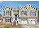 Charming split-level home featuring light-green siding, black shutters, and a convenient two-car garage at 760 Josh Ln, Lawrenceville, GA 30045