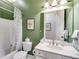 Cozy bathroom with green walls, a white vanity, and a shower with a patterned curtain at 2421 Saint Davids Nw Sq, Kennesaw, GA 30152
