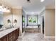 Bathroom featuring a double sink vanity, soaker tub, and tile flooring at 2421 Saint Davids Nw Sq, Kennesaw, GA 30152