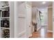 Hallway with hardwood floors, leading to a staircase, and a bookshelf stocked with books and wine bottles at 2421 Saint Davids Nw Sq, Kennesaw, GA 30152