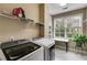 Bright laundry room features a large window, white tile flooring, and modern appliances at 2421 Saint Davids Nw Sq, Kennesaw, GA 30152