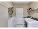 Spacious laundry room with sink, shelving, and front load washer and dryer at 2421 Saint Davids Nw Sq, Kennesaw, GA 30152