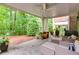 Covered patio with wicker seating and a view of the lush backyard landscape at 2421 Saint Davids Nw Sq, Kennesaw, GA 30152