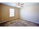 A carpeted bedroom with a ceiling fan and a bright window at 3480 Buffington Ln, Cumming, GA 30040