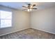 A cozy bedroom with neutral carpet, a ceiling fan, and a window at 3480 Buffington Ln, Cumming, GA 30040