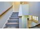 A staircase with carpet and wooden railing leading to an open living space at 3480 Buffington Ln, Cumming, GA 30040
