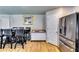 A contemporary dining area features a long wood table with black chairs, stainless refrigerator and neutral walls at 60 Bridgemill Dr, Covington, GA 30014