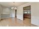 View of the dining room featuring hardwood floors, chandelier, and view into the kitchen at 6046 China Rose Ln, Duluth, GA 30097