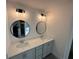 Stylish bathroom with double sinks, quartz countertops, and round mirrors with modern vanity lighting at 3047 Abelia Dr, Buford, GA 30519