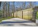 Flat concrete area with wooden fence, bordering a green lawn and wooded area at 4279 Castle Pines Ct, Tucker, GA 30084