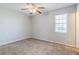 Neutral bedroom featuring a ceiling fan, a window, and carpeted flooring, creating a comfortable atmosphere at 4821 Mainstreet Valley Trce, Stone Mountain, GA 30088