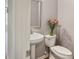 Half bathroom with pedestal sink, toilet, and decorative mirror at 5446 Waterfall Ct, Atlanta, GA 30349