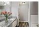 Bright bathroom featuring a granite countertop, white cabinets, and wood-look flooring at 5446 Waterfall Ct, Atlanta, GA 30349