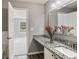 Bathroom with granite countertop, white cabinets, and wood-look floors, leading into a bedroom at 5446 Waterfall Ct, Atlanta, GA 30349