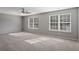 Large bedroom with neutral carpet, a ceiling fan, and lots of natural light from two windows at 5446 Waterfall Ct, Atlanta, GA 30349