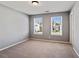 A bright bedroom features neutral carpet, two windows with white blinds, and light gray walls at 5446 Waterfall Ct, Atlanta, GA 30349