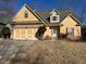 Charming yellow home with a stone-accented facade and well-maintained lawn at 9996 Village South Dr, Douglasville, GA 30135