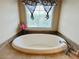 Bathroom features large white soaking tub under window and tiled flooring at 101 Talking Leaves Ct, Acworth, GA 30101