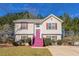 Charming two-story home with vibrant pink stairs and shutters, nestled among mature trees at 3420 Lineview Dr, Ellenwood, GA 30294