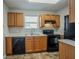 Functional kitchen with wooden cabinets, black appliances, and a double sink at 3420 Lineview Dr, Ellenwood, GA 30294