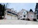 Stately brick home featuring a 3-car garage, dormers, and manicured landscaping at 8630 Moor Park Run, Duluth, GA 30097