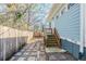 Backyard with a stone paver patio, wooden fence and small steps to porch at 1057 Regent Sw St, Atlanta, GA 30310