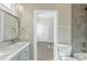 Bathroom featuring a grey vanity, large mirror, and a tiled bathtub at 1057 Regent Sw St, Atlanta, GA 30310