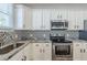 Modern kitchen featuring white cabinetry, black hardware, and a stainless steel stove at 1057 Regent Sw St, Atlanta, GA 30310