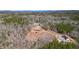 Aerial shot of a vast property with a home, pool, solar panels, and outbuildings amidst lush trees at 2150 Fincher Rd, Canton, GA 30114