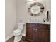 Powder room featuring a round mirror, granite countertop, and wood-look tile flooring at 2150 Fincher Rd, Canton, GA 30114