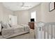 Neutral bedroom featuring a bed, crib, wooden dresser, and a ceiling fan with a light at 2150 Fincher Rd, Canton, GA 30114