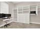 Bright walk-in closet with custom white shelving, drawers, a built-in desk, and carpeted flooring at 2150 Fincher Rd, Canton, GA 30114