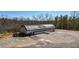 View of the property with a large metal building and parking area nestled in a wooded setting at 2150 Fincher Rd, Canton, GA 30114