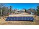 Spacious property featuring a large solar panel array and a white fence along the yard at 2150 Fincher Rd, Canton, GA 30114