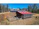 Exterior view of a small building with a red roof, solar panels, and fencing on a sunny day at 2150 Fincher Rd, Canton, GA 30114