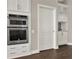 Gourmet kitchen features built-in double ovens, white cabinetry, and dark hardwood floors at 2150 Fincher Rd, Canton, GA 30114