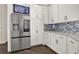 Modern kitchen with stainless steel refrigerator and TV above, white cabinets and dark flooring at 2150 Fincher Rd, Canton, GA 30114